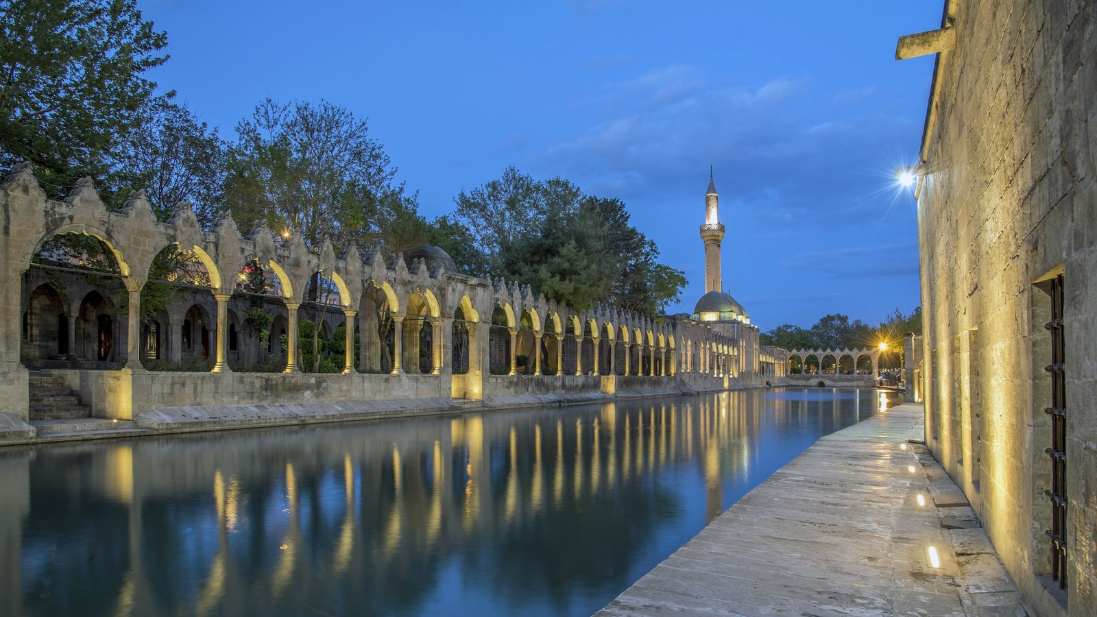 Balıklıgöl, em Şanlıurfa, ao anoitecer — arcadas de pedra refletidas na água