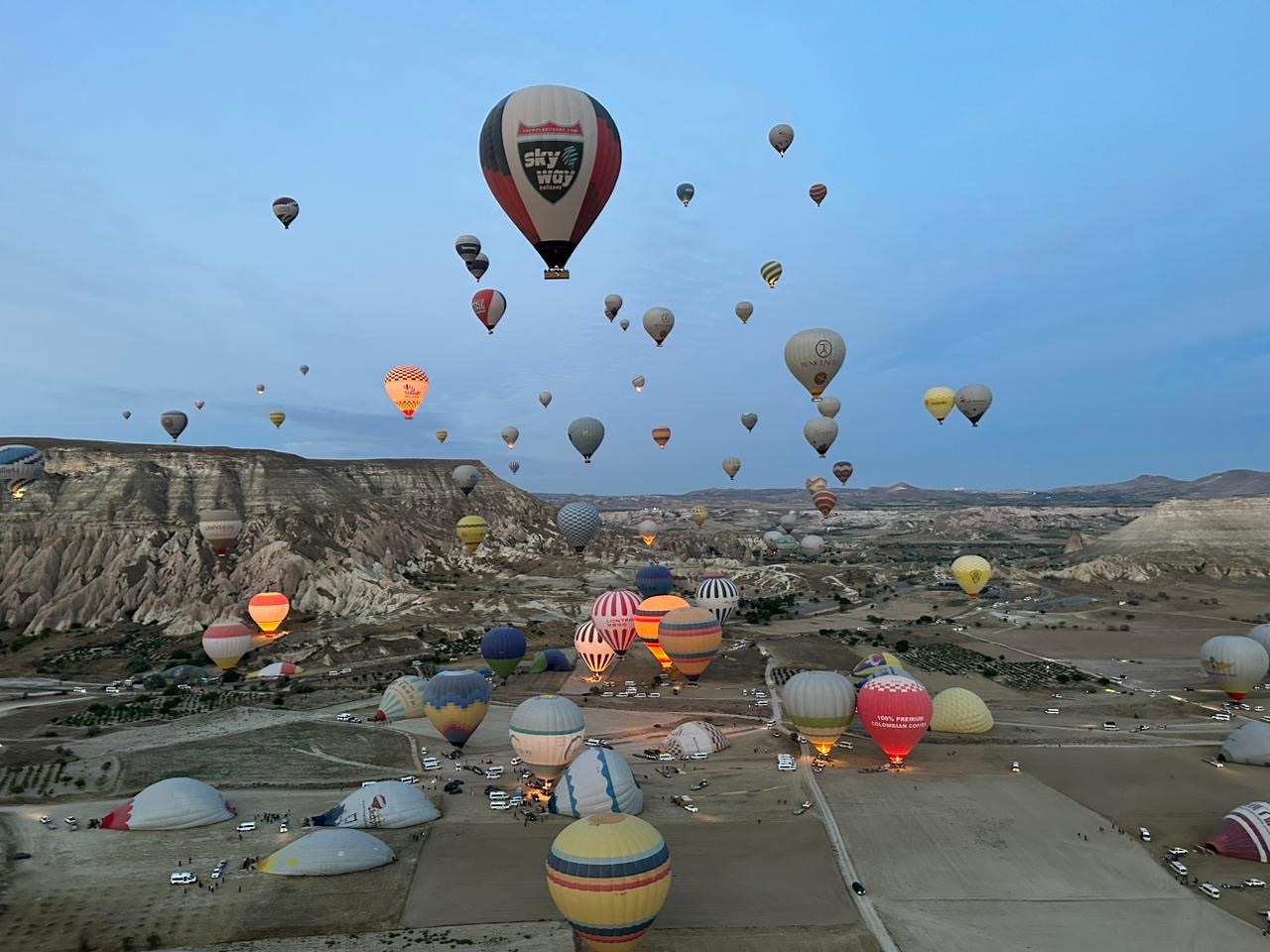 Balões decolando ao amanhecer, vistos do alto na Capadócia