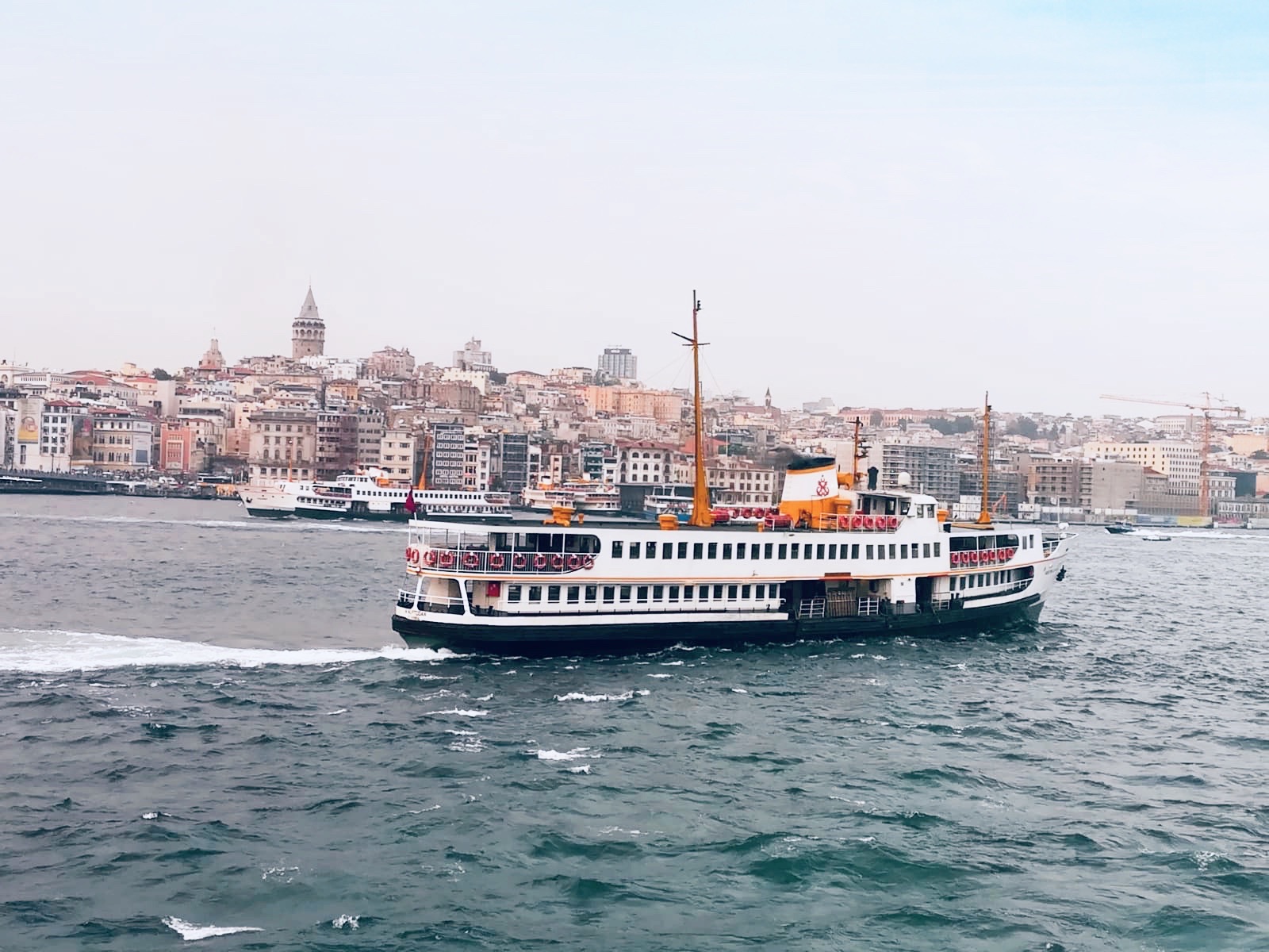 Balsa cruzando o Bósforo com a Torre de Galata ao fundo